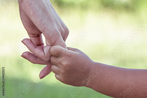 child and mother holding hand together with love in the park © pingpao