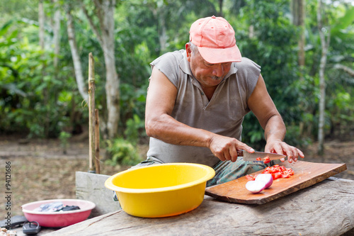 A simple potato salad being prepared in the jungle  with a chef chopping fresh ingredients surrounded by lush greenery.