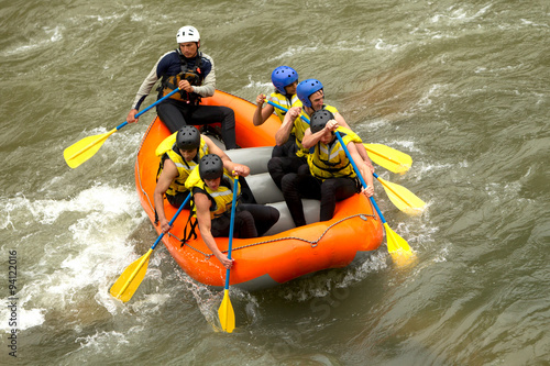 A group of tourists enjoying a thrilling whitewater rafting adventure on a scenic river in Ecuador.
