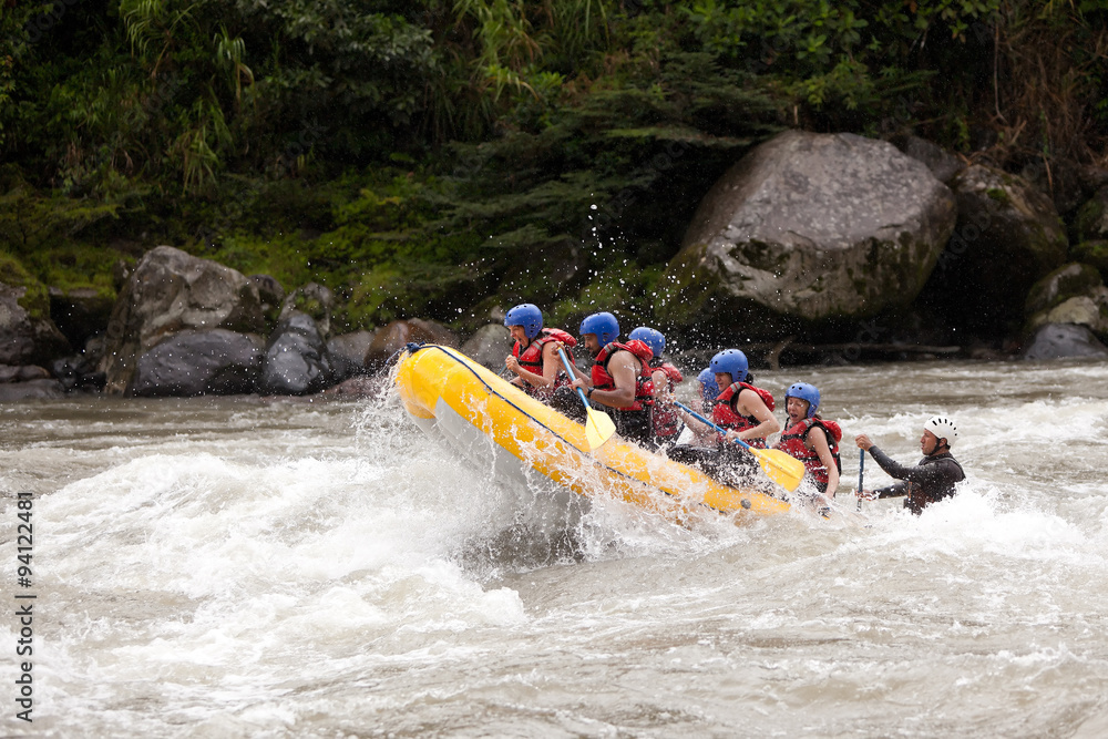 A team of adventurers navigate a white-water river in Ecuador on a raft, braving dangerous rapids for an extreme and risky challenge.
