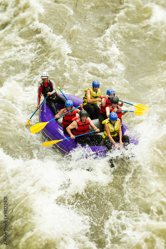 A family enjoying a thrilling white water rafting adventure together, working as a team to navigate the rushing waters.