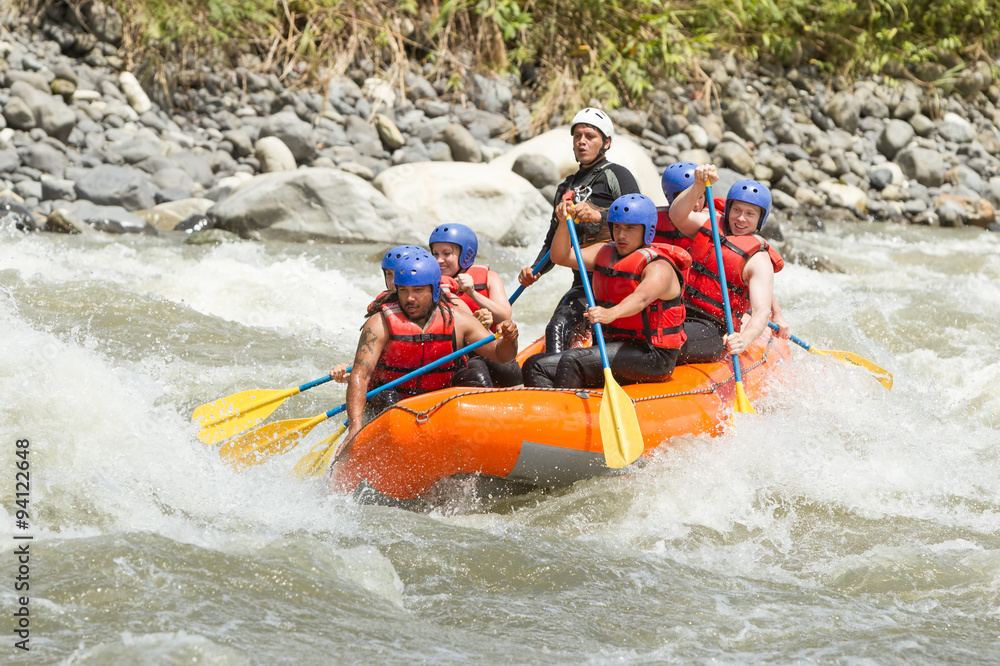 A team of adrenaline junkies navigates through the white waters of an Ecuadorian river on a thrilling rafting expedition, laughing and rowing with determination.