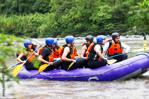 Adventure awaits! Group of enthusiastic tourists gearing up for an adrenaline pumping whitewater rafting expedition ready to embrace the thrill of the rapids