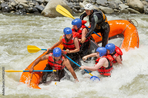 A thrilling white water rafting adventure on a red river during a vacation, with crystal clear water rushing past the raft. photo