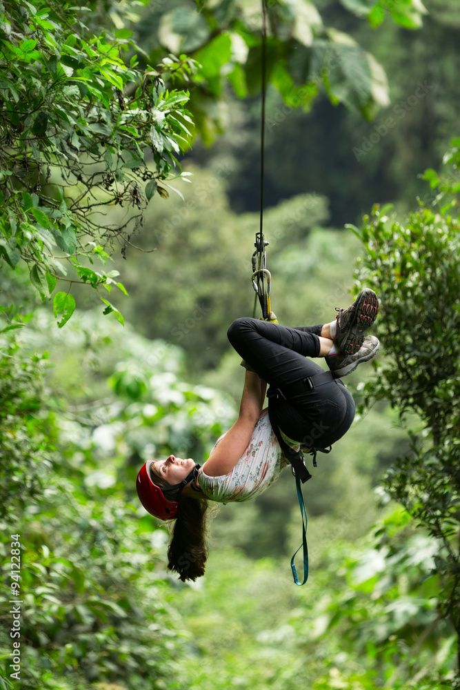 A woman zipping through the treetops on a thrilling adventure, following the line of a zipline.