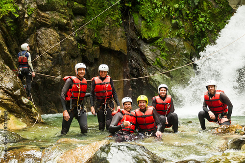 A group of friends in Ecuador embarking on an extreme canyoning adventure, navigating through the mountainous terrain as a team.