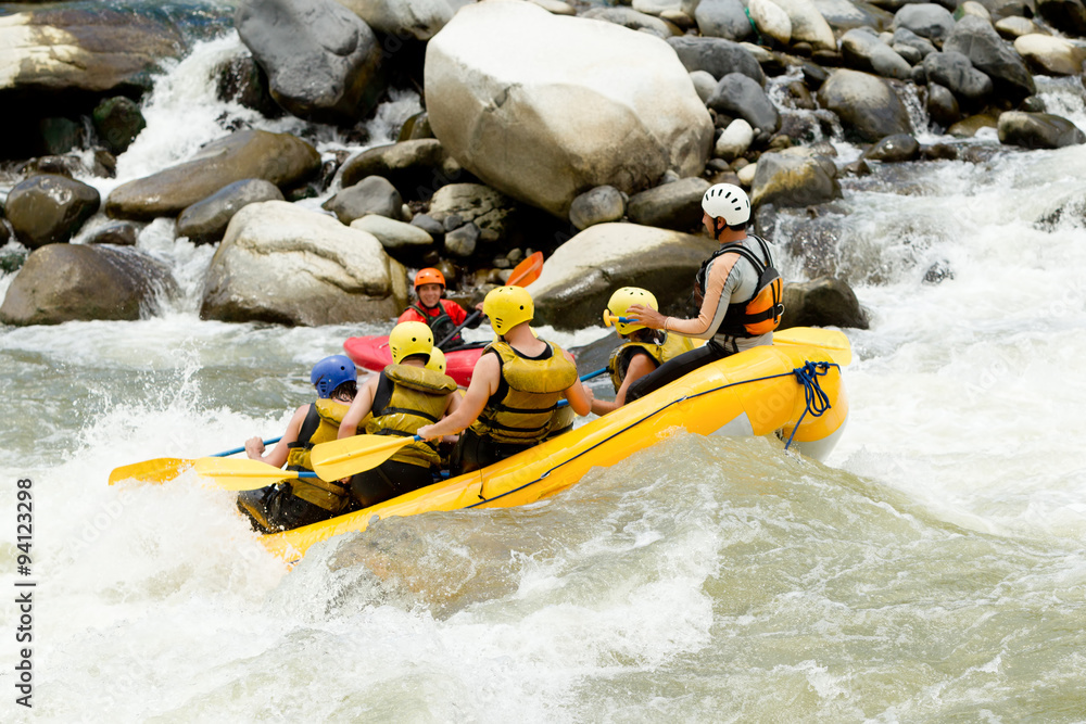 A team of experienced guides navigate the whitewater rapids in kayaks and rafts, working together to conquer the rushing river.