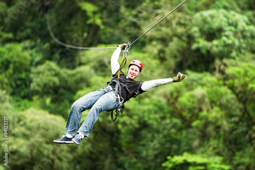 An exhilarating zipline adventure through the lush Ecuadorian rainforest canopy, soaring above the trees on a secure wire for an unforgettable experience.