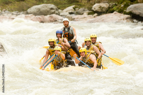 A team of men rowing a raft through the extreme whitewater of Pastaza river, guided by an experienced leader, ensuring a fun and thrilling tourist adventure.