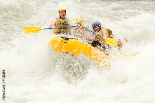 A woman navigating through white water rapids on a raft, surrounded by the beauty of nature and feeling the adrenaline rush of extreme sports.