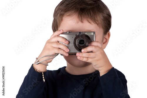 Curious kid mastering the art of photography using a compact digital camera in the classic snapshot stance capturing moments with enthusiasm