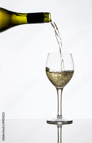 pouring white wine into a glass