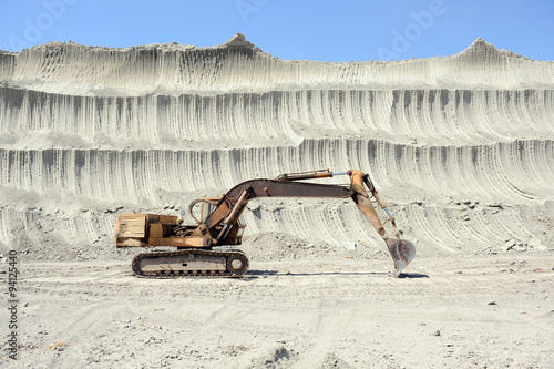 Yellow excavator in mine photo