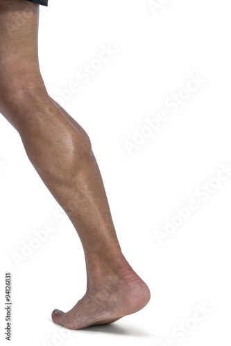 Muscular man flexing leg for camera