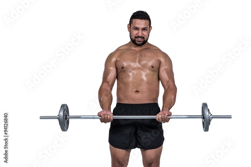 Muscular man lifting heavy barbell