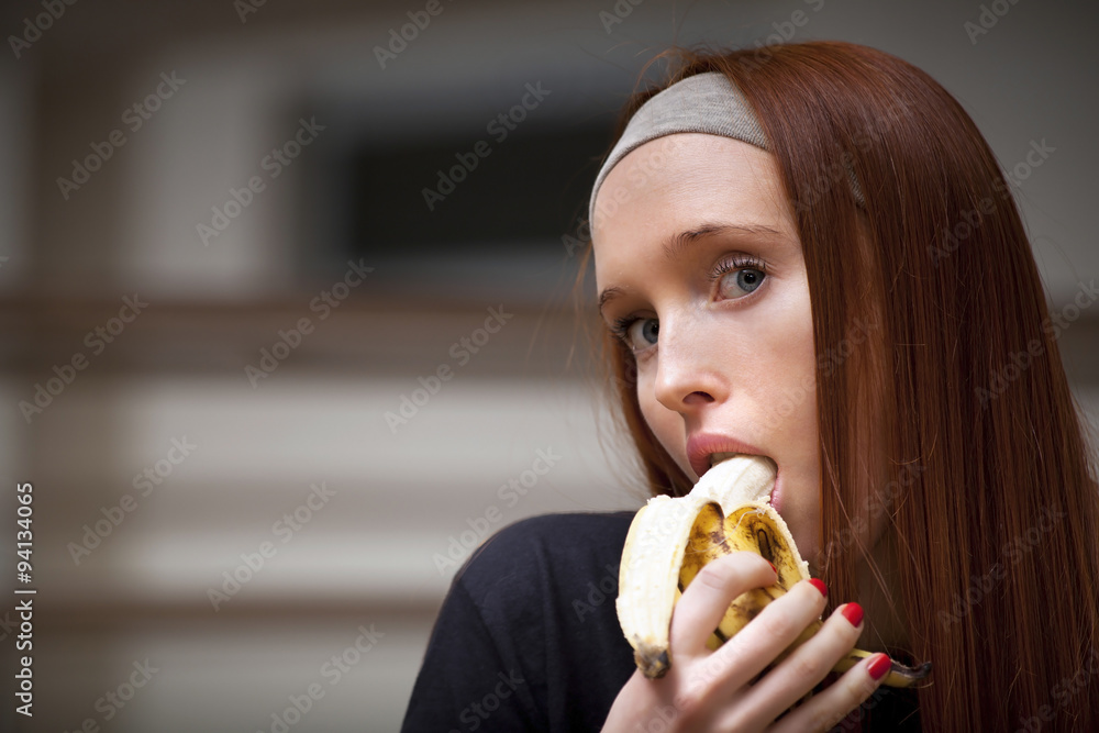 Woman is sitting in sport saloon and eating banana Woman is sitting in sport saloon and eating banana