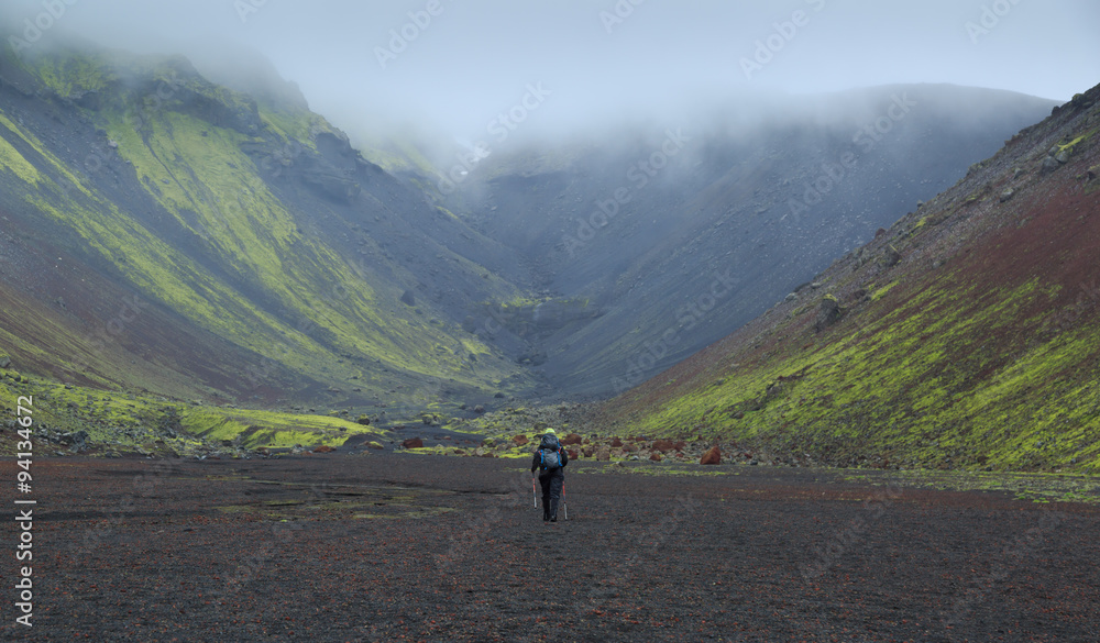 Female hiker in the canyon of national park Eldgja in Iceland on a rainy day.