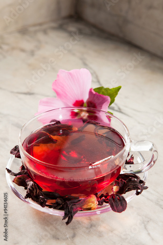 Frische und getrocknete Malvenblüten mit einer Tasse Malvenblütentee