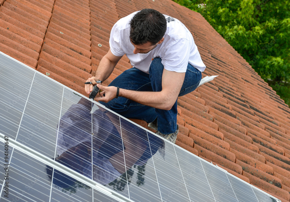 electrician on roof with curved tiles measuring for solar panel electrician on roof with curved tiles measuring for solar panel
