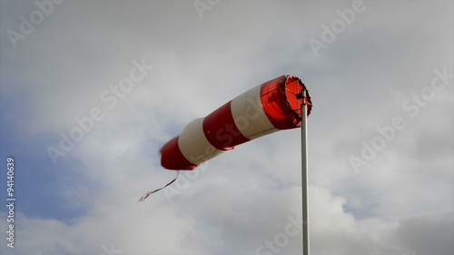 Red and white wind sign turning in the wind on a summer's day. photo