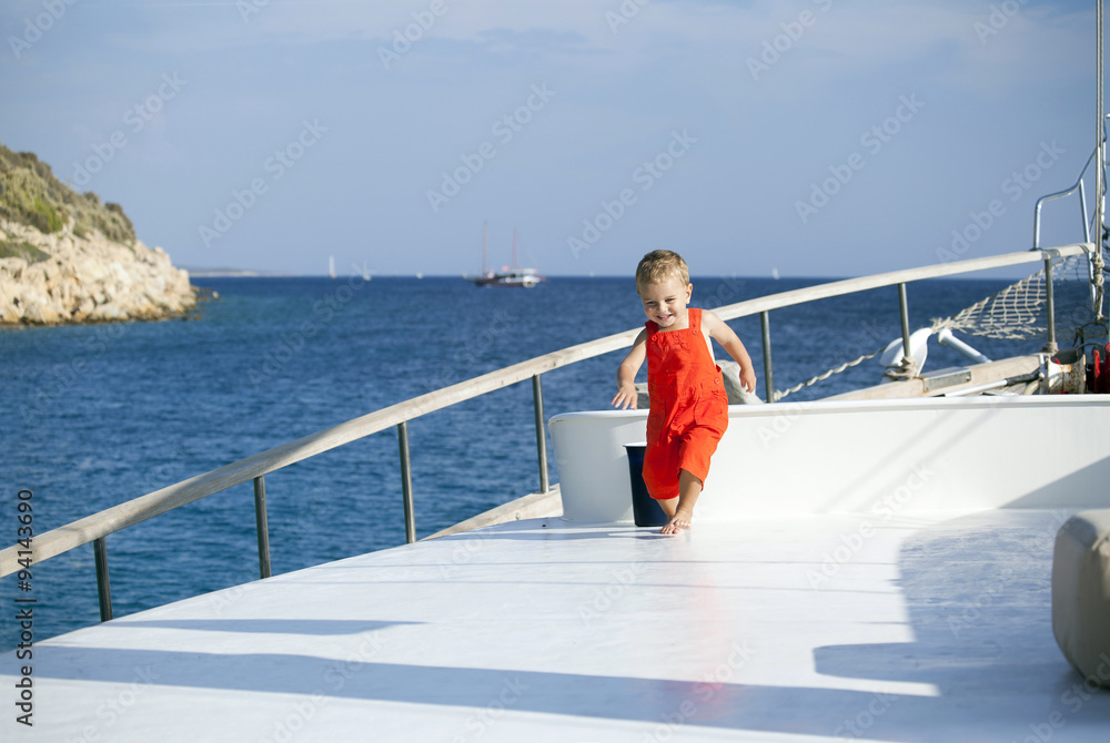 Fototapeta premium Lovely handsome boy running on a boat