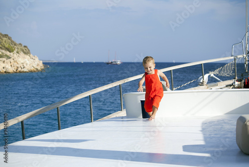 Lovely handsome boy running on a boat