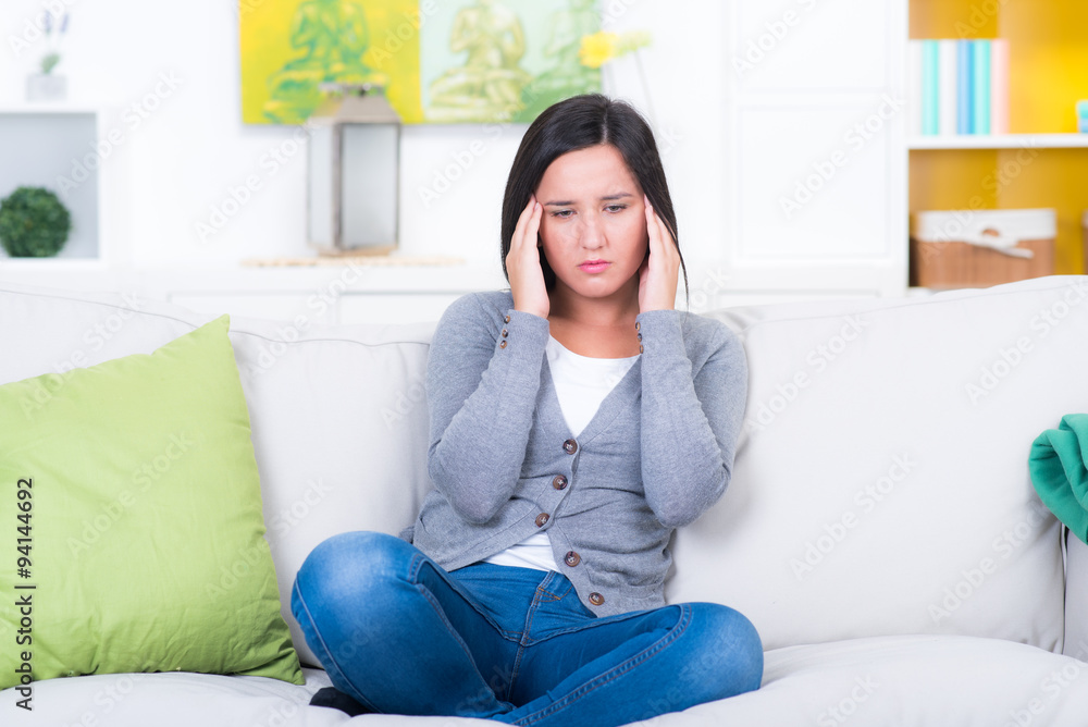 Trauriges Mädchen hat Kopfweh auf dem Sofa Trauriges Mädchen hat Kopfweh auf dem Sofa