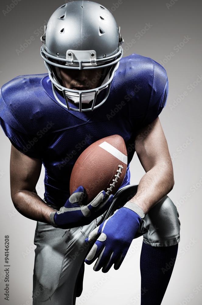 Portrait of american football player holding ball