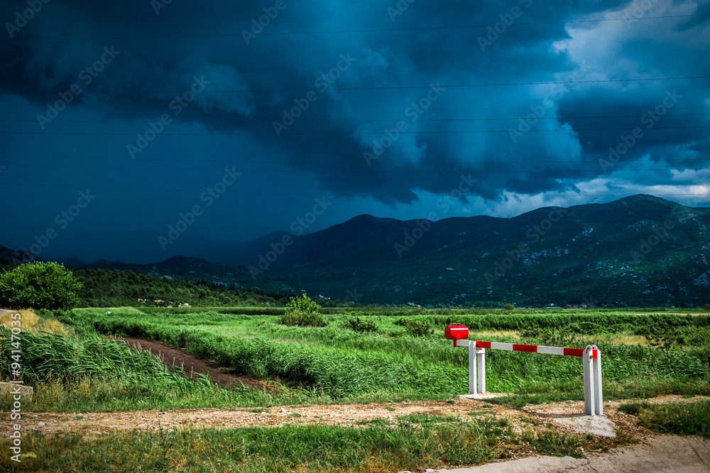 Naklejka premium Rural landscape and the blue dramatic sky with clouds
