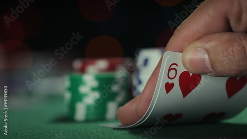 Poker Hand Fold. camera dollies from left to right on texas hold em hand. person looks at their hand and folds cards. throws them away.
 photo