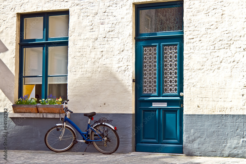 Quaint home with blue door and blue window matching blue bicycle