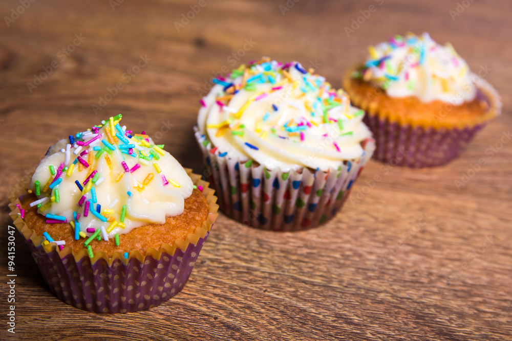 close up of tasty colorful cupcakes with butter cream and cinnam