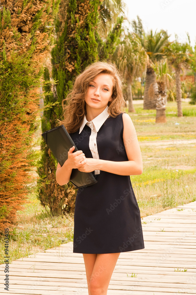 Naklejka premium beautiful teenager on campus with her folder of notes