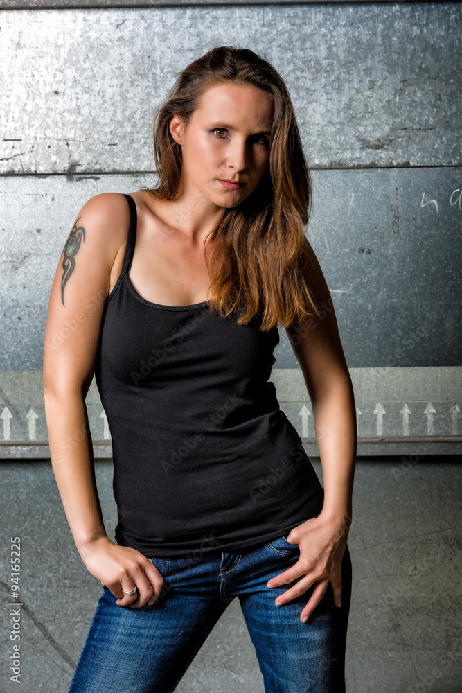 Trendy Woman in blue jeans posing in the grungy underground Trendy Woman in blue jeans posing in the grungy underground