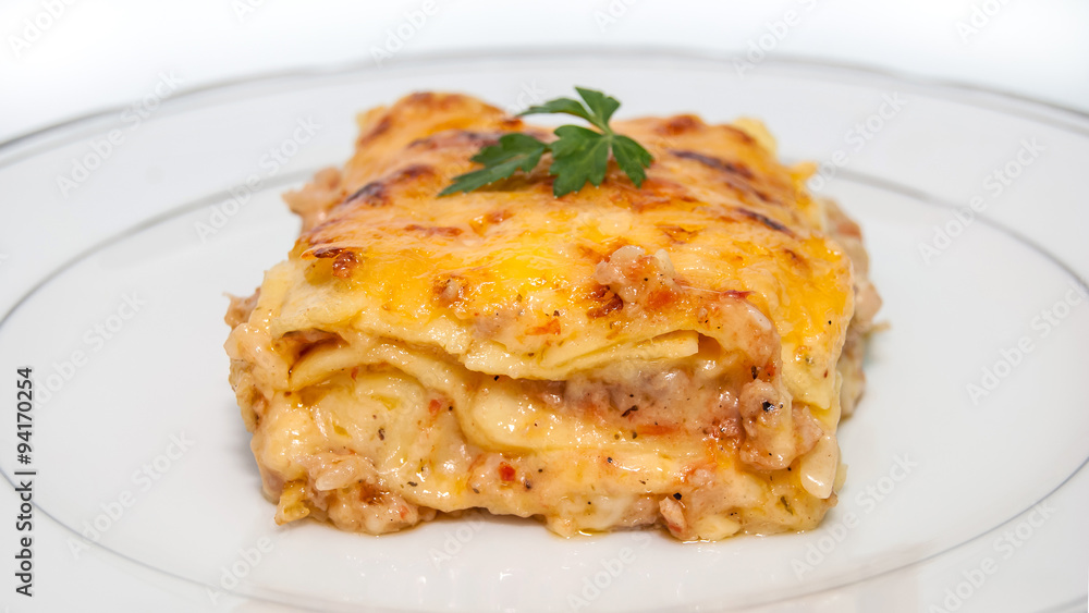 Portion of lasagna with meat isolated on plate