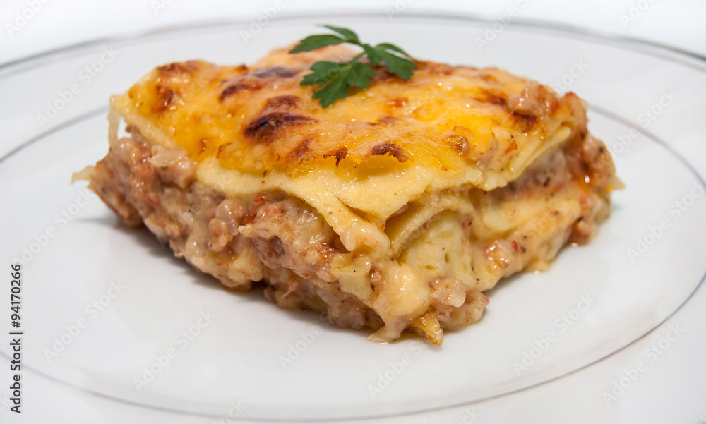 Portion of lasagna with meat isolated on plate