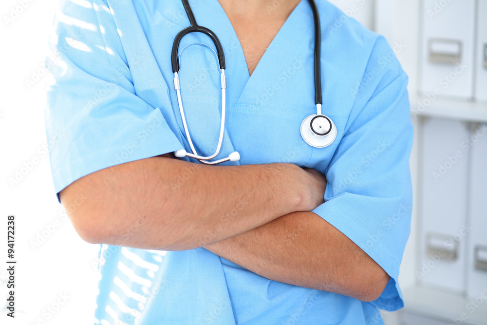 Portrait of unknown male surgeon doctor holding his stethoscope, crossed arms Portrait of unknown male surgeon doctor holding his stethoscope, crossed arms