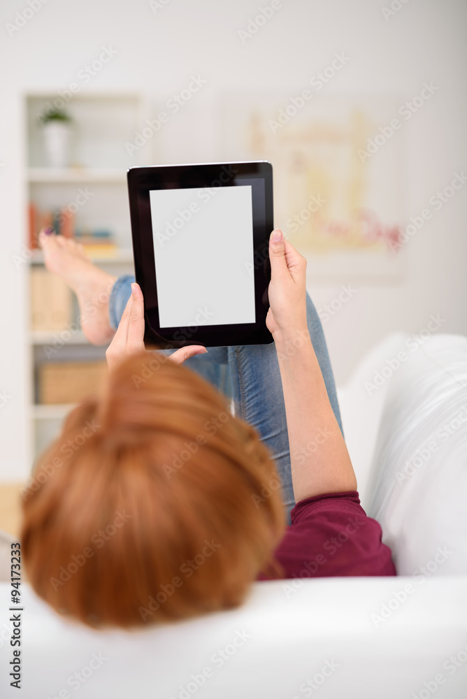frau genießt die freizeit zuhause und liest etwas am tablet-pc