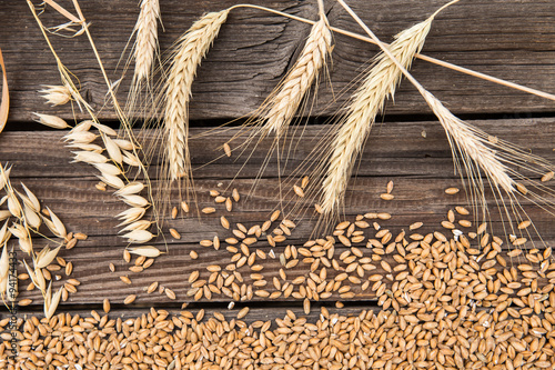 Ears of wheat on old wooden table © Lubos Chlubny