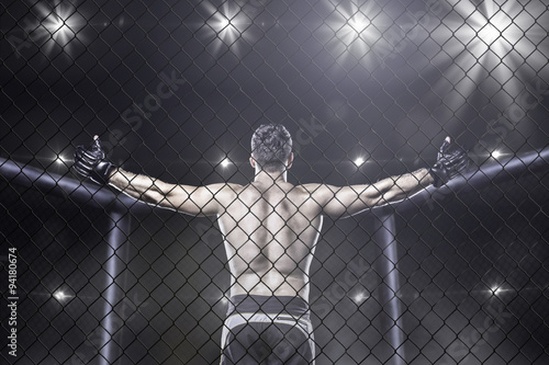 mma fighter in arena celebrating win, behind view