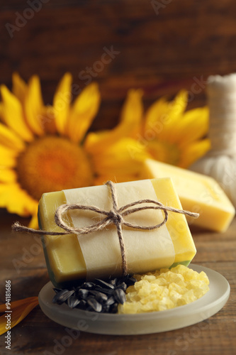 Fototapeta Naklejka Na Ścianę i Meble -  Soap bar and Spa treatments and sunflower on wooden background