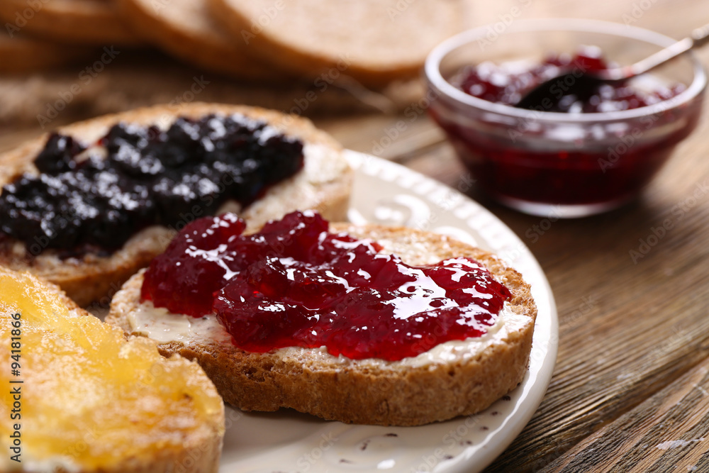 Fresh toast with butter and different jams on table close up Fresh toast with butter and different jams on table close up