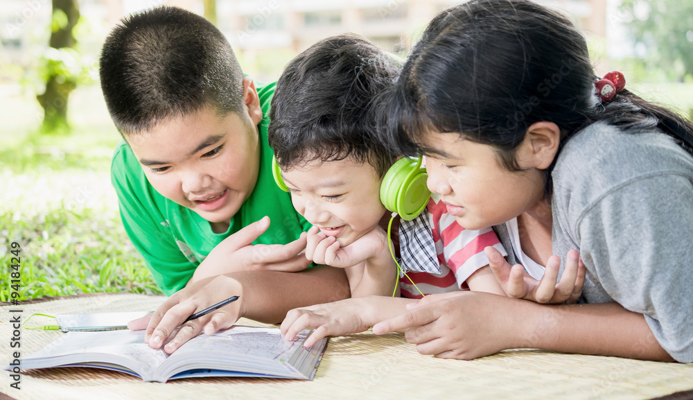 Three happy children resting in the park