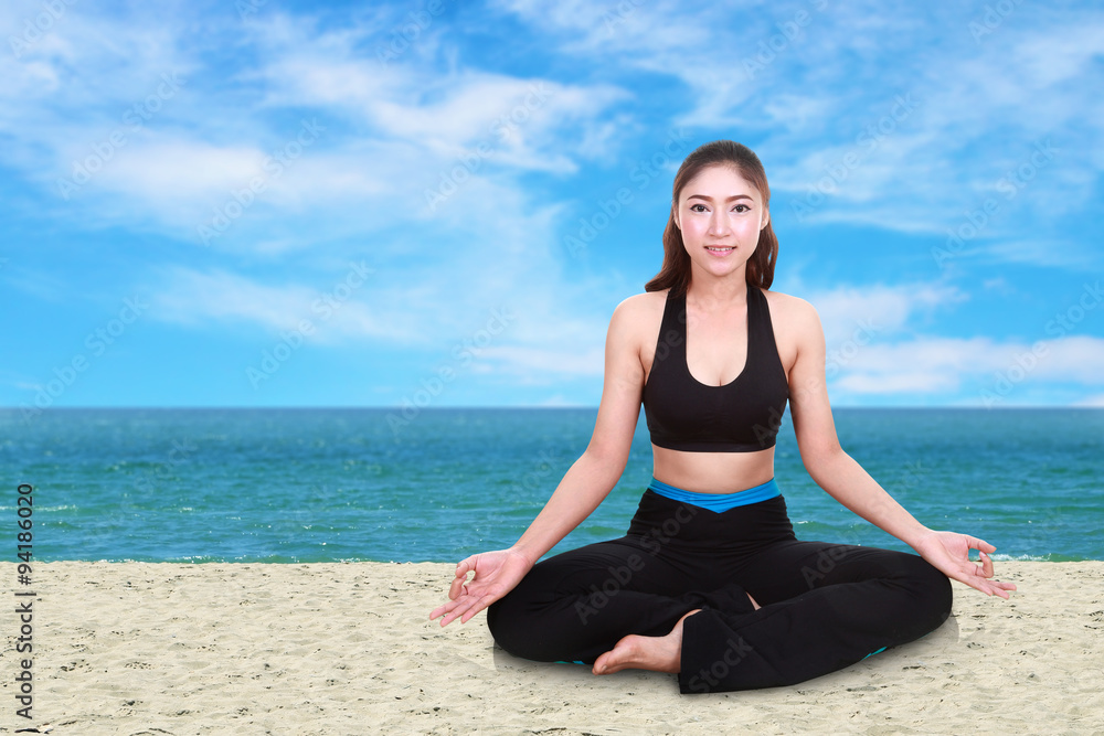 woman doing yoga exercise on the beach