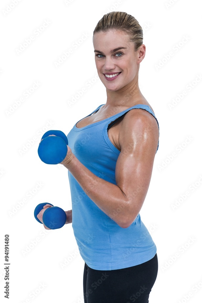 Muscular woman exercising with dumbbells Muscular woman exercising with dumbbells