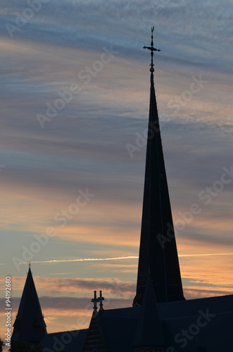 Obraz na plátně Church tower with cross against clouds and sunset, Kontich