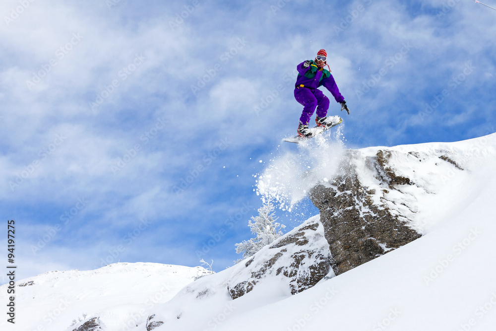 Awesome snowboarder jumps of a cliff in Les Portes du Soleil in France