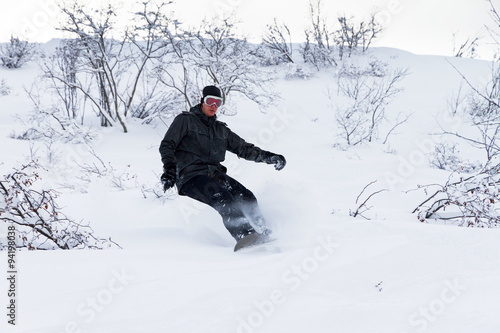 Awesome snowboarder is having fun in the backcountry powder of Les Portes du Soleil in France