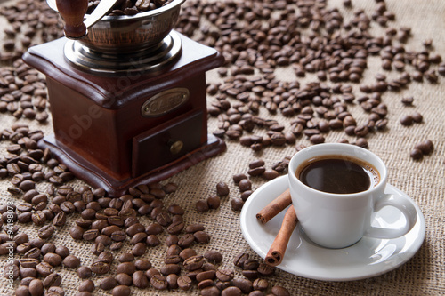 cup of coffee with cinnamon on a background coffee beans