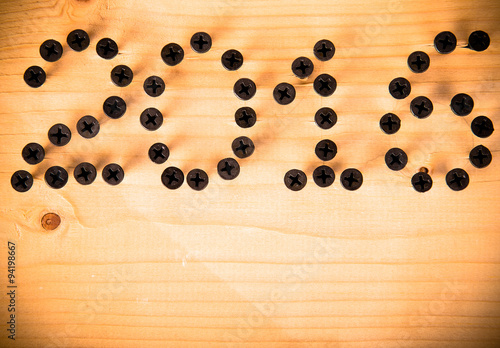 The number 2016 of screw on a light wooden background. Christmas